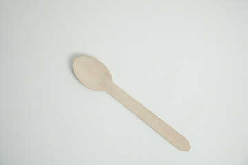 A single, eco-friendly wooden spoon rests on a clean white background. This image is perfect for concepts of sustainability, zero-waste, and environmentally conscious dining.