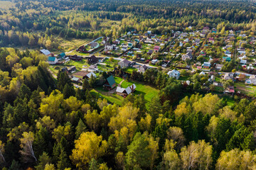 Aerial view of a dacha development sprawling beyond the forest