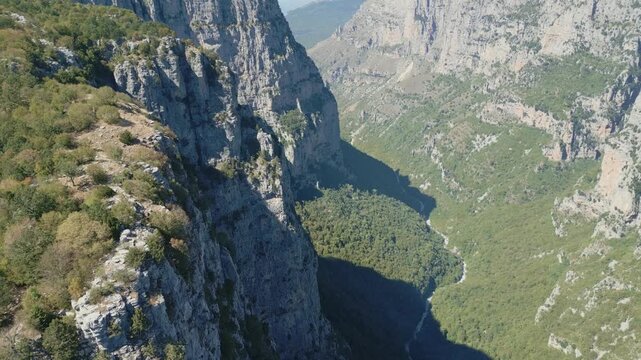 Drone footage of Vikos Gorge in Epirus, Greece, showing steep cliffs, lush greenery, and dramatic mountain landscape. Perfect for travel, nature, and documentary projects.