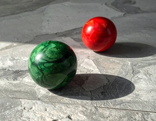Two colorful spheres on a stone surface