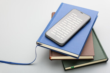 Smartphone and books stacked together symbolizes access to knowledge through both digital and physical formats, suitable for education or information search themes