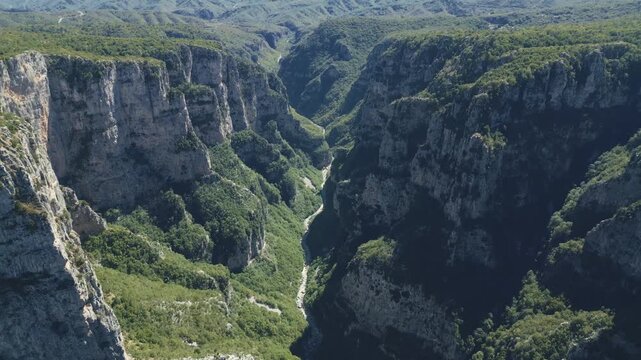 Drone footage of Vikos Gorge in Epirus, Greece, showing steep cliffs, lush greenery, and dramatic mountain landscape. Perfect for travel, nature, and documentary projects.
