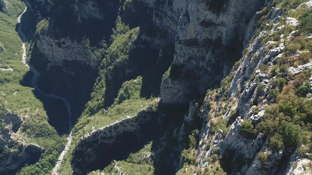 Drone footage of Vikos Gorge in Epirus, Greece, showing steep cliffs, lush greenery, and dramatic mountain landscape. Perfect for travel, nature, and documentary projects.