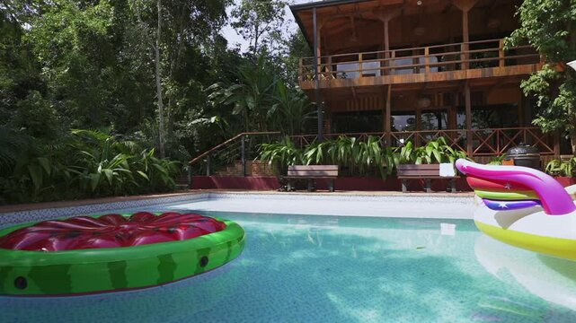 Selva Jungle Cabin Lodge in Misiones, Argentina shows a serene pool with colorful floats, surrounded by vibrant jungle, wooden cabin architecture, and the peaceful rhythm of the Selva Misionera