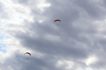 Close-up of two people paragliding in the sky, adventure sport, tandem flight, aerial recreation
