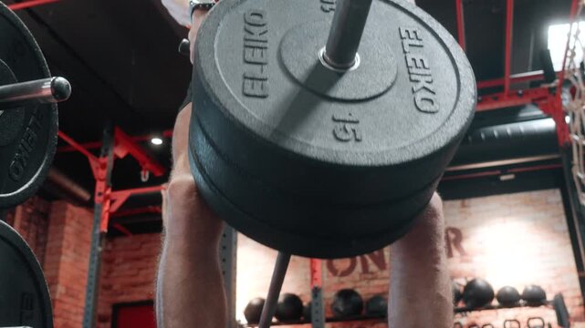 close-up shot of a man performing controlled weighted T-bar rows in the gym