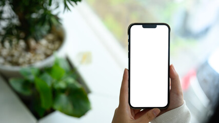 Hands holding a smartphone with blank white screen, ready for app mockup or design presentation