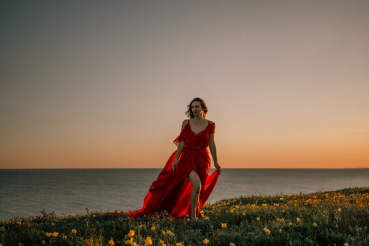 Dress woman sunset, model walks seaside meadow during dusk for elegant portrait - Powered by Adobe