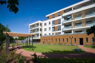 Modern apartment building with a green courtyard and wooden pergola
