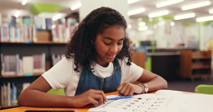 Child, student and writing for education in library with workbook, studying and learning. Girl, elementary school and book for creative assessment, assignment solution and information for knowledge