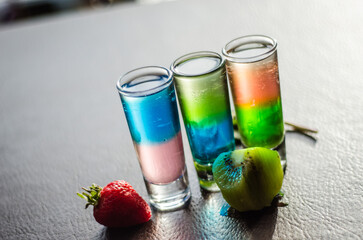 Colorful Layered Alcoholic Shooters Trio with Fresh Fruit Garnish