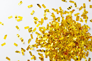 Pile of gold confetti on a white background