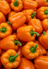 Close-up photo scotch bonnet peppers. Wallpape, Yellow and orange caribbean chili peppers with green stems. Variety of capsicum fruits. Fresh vegetables at market.