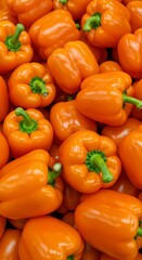 Close-up photo scotch bonnet peppers. Wallpape, Yellow and orange caribbean chili peppers with green stems. Variety of capsicum fruits. Fresh vegetables at market.