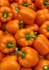 Close-up photo scotch bonnet peppers. Wallpape, Yellow and orange caribbean chili peppers with green stems. Variety of capsicum fruits. Fresh vegetables at market.