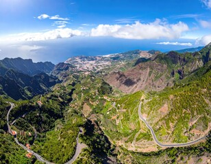 Winding road through verdant valleys to coastal town afar