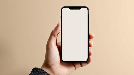 Hand holding phone with blank screen on beige background, showcasing screen mockup, advertisement