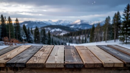 Rustic wooden table surface with a blurred snowy mountain landscape and pine forest in the winter background