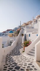 Fototapeta premium Narrow cobblestone alleyway with whitewashed buildings and blue domes in santorini greece