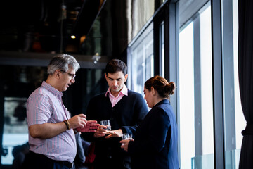 Indian and White Business partners exchanging ideas at a corporate event, showcasing teamwork, collaboration, and professional growth in a stylish environment.