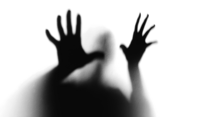 Scary silhouette of person with hands against surface, isolated on transparent cutout background