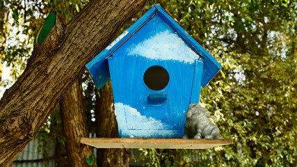 Blue birdhouse hanging from tree 