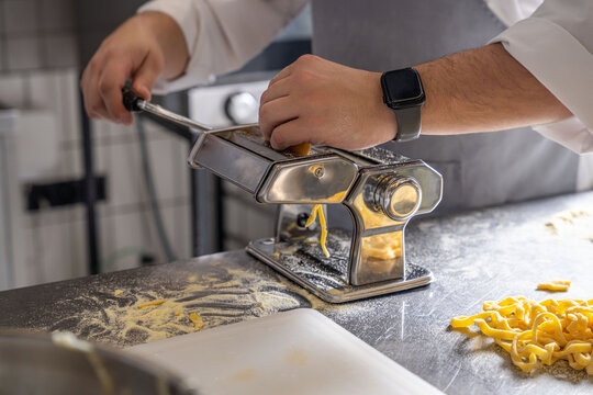 Chef preparing fresh pasta with machine - Powered by Adobe