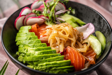 Salmon avocado noodle bowl with vegetables