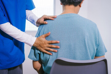 An Asian female nurse provides caring home care to an elderly woman, assisting with arm movement exercises, physical therapy,and rehabilitation to improve joint function, strength,overall well-being