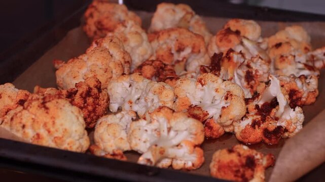Oven-baked cauliflower florets topped with a flavourful sauce made from olive oil, sweet paprika, garlic, and cumin, perfect for a healthy dinner.