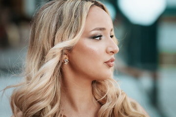Glamorous close-up portrait of a caucasian woman with curly blonde hair and makeup