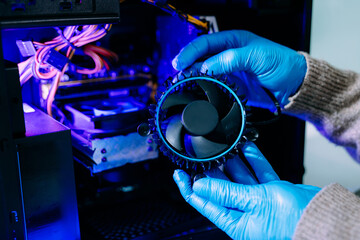 Closeup of technician in gloves holding CPU cooler and heat gun over desktop PC. Ideal image for computer repair, cooling system, and hardware