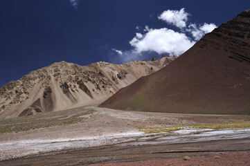 A small river flowing through a valley between mountains. A mountain river that has dried up during the dry season