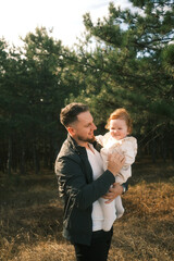 Fototapeta premium A father joyfully holding his daughter while enjoying the beauty of nature around them