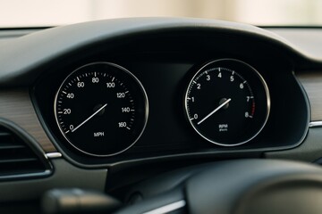 Close-up view of modern car speedometer and tachometer dashboard with analog gauges and glossy dials in natural light and soft background concept. Ai generative