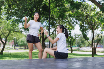 Young women pointing and talking outdoors in park