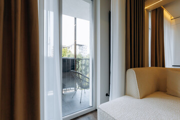 A Modern Lounge featuring a Beautiful Balcony View along with Stylish, Elegant Curtains