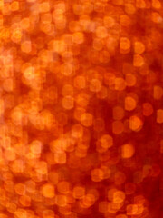 Abstract orange bokeh background with hexagonal light reflections