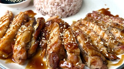 Close up teriyaki chicken and rice berry is background.