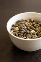baked salted pumpkin seeds in a small white bowl