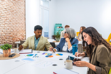Diverse business team collaborating on project analytics in modern office