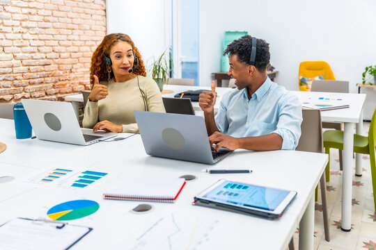 Diverse coworkers celebrating teamwork success giving thumbs up