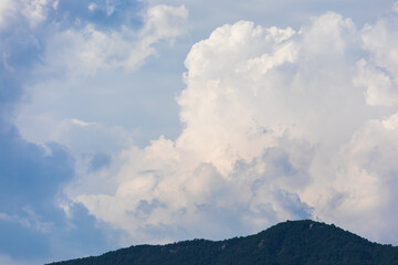 Massive White Cumulus Clouds Rising Above Mountain Ridge