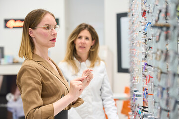 Woman choosing new eyeglasses at optical store