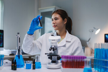 Female scientist analyzing blood sample in medical laboratory
