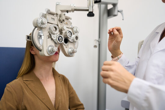 Woman having vision test using phoropter equipment