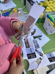 A girl cuts paper with scissors at a collage workshop