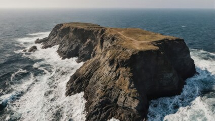 Rocky island, dramatic coastline.  Waves crash against a rugged, dark gray cliff face.  Elevated view of the isolated island