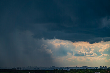 Obraz premium Stormy weather approaches the city skyline, with dark clouds signaling an impending rain shower