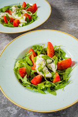 Brightly colored salad featuring juicy tomatoes, creamy cheese, and fresh greens on display